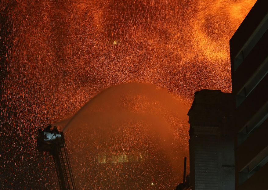 Fire crews from Des Moines work to control a fire at the Younkers building in downtown Des Moines, Iowa early Saturday, March 29, 2014. The massive fire swept through a century-old building that was being renovated, causing its upper floors to collapse and authorities to close down numerous streets in downtown Des Moines. No one was injured. Des Moines Fire Department spokesman Brian O'Keefe said it first got word of a fire at the former Younkers department store building at about 12:50 a.m. Saturday, and arrived to find flames leaping from the upper floors of the seven-floor building, which dates to 1899. (AP Photo/The Des Moines Register, Bryon Houlgrave) MANDATORY CREDIT THE DES MOINES REGISTER BRYON HOULGRAVE