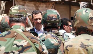 Syrian President Bashar Assad talking with soldiers with during Syrian Arab Army day in Darya, Syria. (AP Photo/Syrian Presidency via Facebook, File)