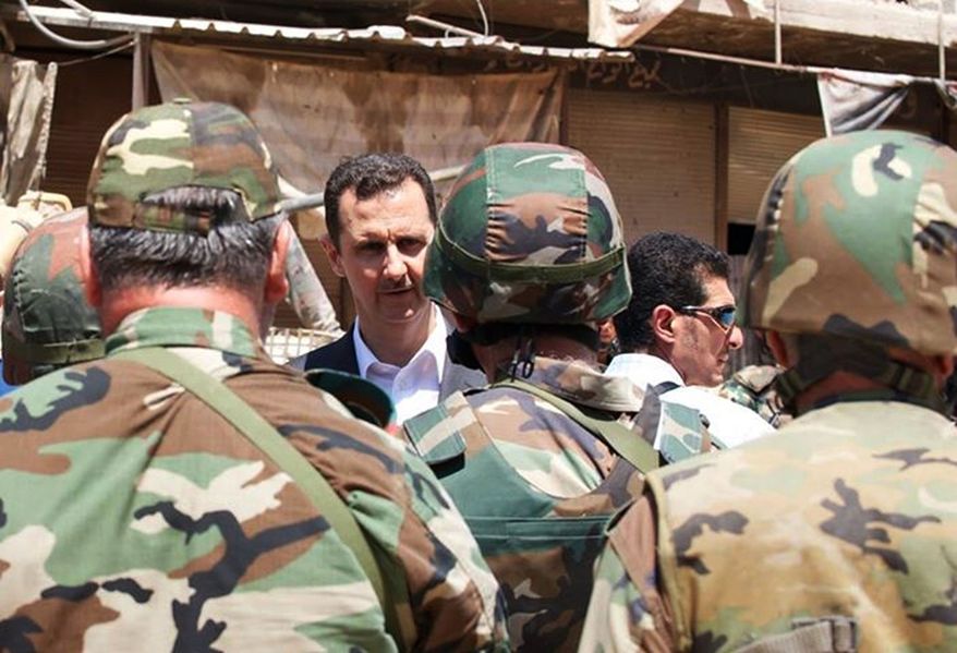 Syrian President Bashar Assad talking with soldiers with during Syrian Arab Army day in Darya, Syria. (AP Photo/Syrian Presidency via Facebook, File)