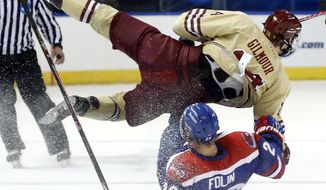 Boston College&#39;s Adam Gilmour (14) and  UMass Lowell&#39;s Christian Folin (26) crash going for the puck in the first period of the NCAA Northeast Regional hockey final in Worcester, Mass., Sunday, March 30, 2014. (AP Photo/Elise Amendola)
