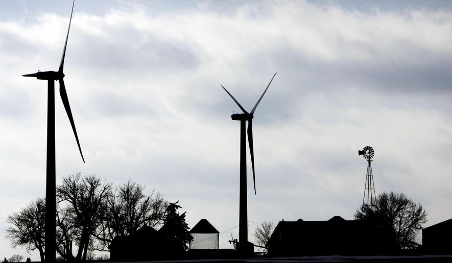 FILE - In this Dec. 30, 2008 file photo, two wind turbines stand near a traditional windmill on a farm near Mount Carmel, Iowa. The Iowa Senate passed bills to triple the amount of solar energy tax credits available to farmers, homeowners, and businesses and to extend the deadline to complete wind turbine projects and still qualify for a tax break. (AP Photo/Charlie Neibergall, File)