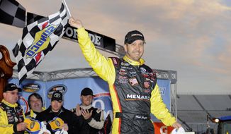 Driver Matt Crafton celebrates in victory lane after winning a NASCAR Truck Series auto race at Martinsville Speedway in Martinsville, Va., Sunday, March 30, 2014. (AP Photo/Mike McCarn)
