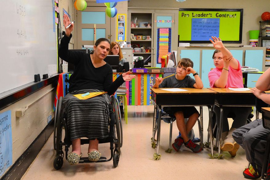 Courtney Carpenter Boyll was a rising star athlete in 1994 when a car wreck left her paralyzed. Twenty years later she is a wife, mother of three and third grade teacher at Moulton Elementary in Alabama, and does it all as a paraplegic. Courtney works with students on their Number of the Day exercise. Beside her are students Cameron Purser and Amber Melson. (AP Photo/ Decatur Daily, Gary Cosby Jr.)