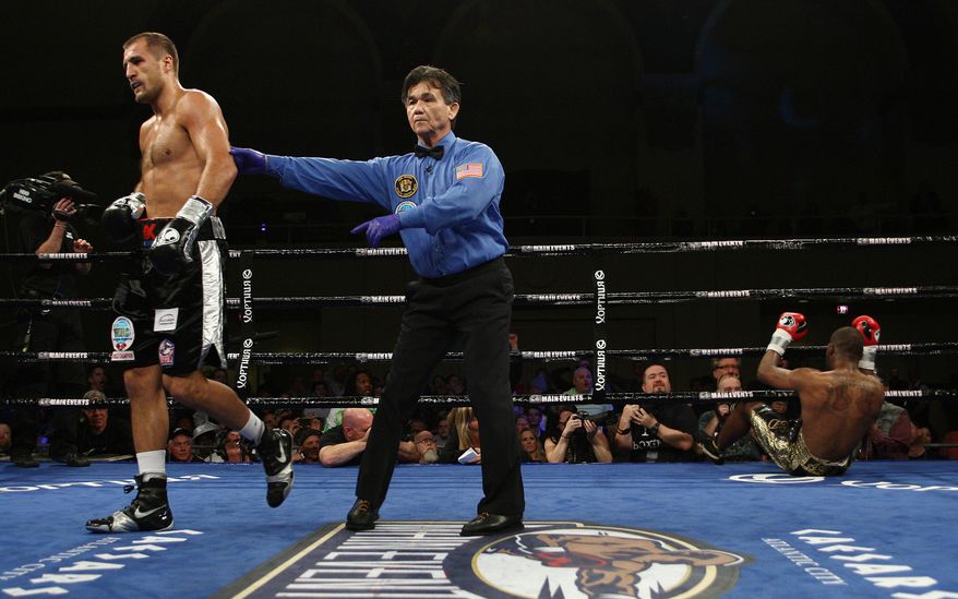 Sergey Kovalev, left, of Russia walks to his corner after knocking down Cedric Agnew, of the United States, during the second round of the WBO light heavyweight title fight in Atlantic City, N.J. on Saturday, March 29, 2014. Kovalev won by knockout in the seventh round. (AP Photo/Tim Larsen)