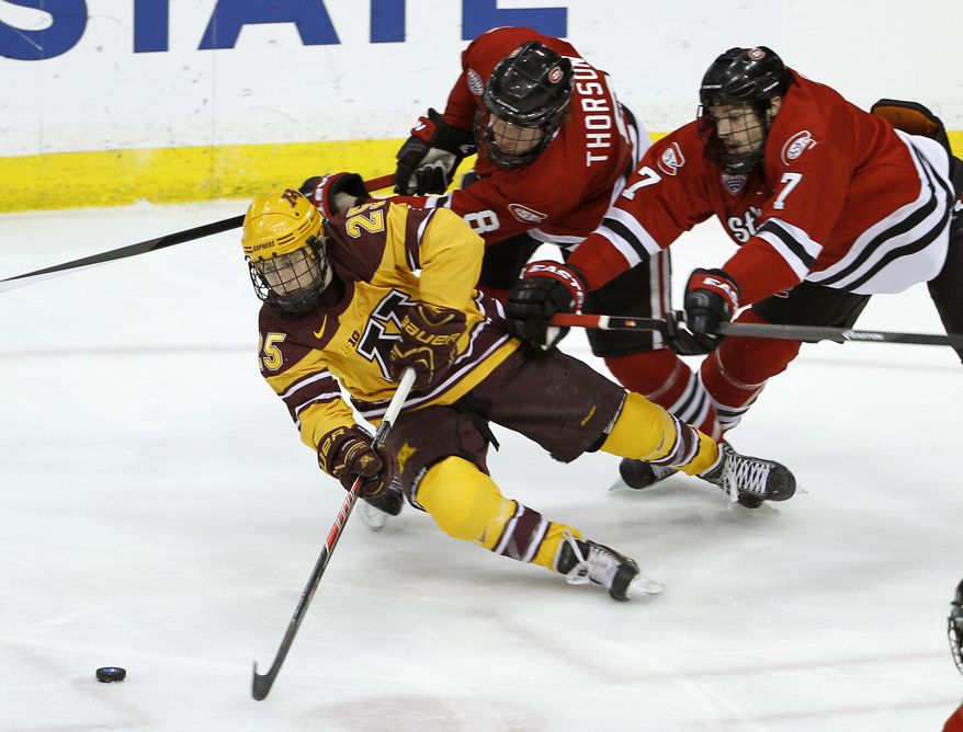 Minnesota forward Justin Kloos (25) battles St. Cloud State forward Cory Thorson (8) and defenseman Kevin Gravel (7) for the puck during the first period of an NCAA West college regional hockey game in St. Paul, Minn., Sunday, March 30, 2014. (AP Photo/Ann Heisenfelt)