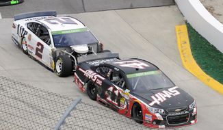 Brad Keselowski (2) bumps Kurt Busch (41) as they enter Turn 1 during a NASCAR Sprint Cup auto race at Martinsville, Speedway, Sunday, March 30, 2014, in Martinsville, Va. The two drivers were involved in a pit road accident earlier in the race. (AP Photo/Mike McCarn)