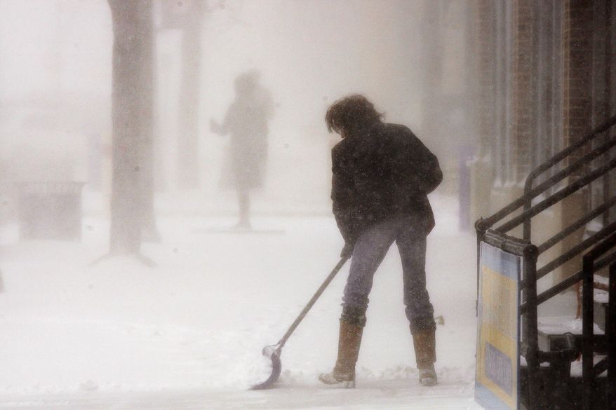 Michelle Bezpaletz shovels the sidewalk in front of her business, Forget-Me-Not Floral for the third time in two hours on Monday March 31, 2014 in Rapid City, S.D. A spring snowstorm in the Upper Midwest on Monday shut down public schools, universities and government offices, made travel hazardous and life miserable for cattle ranchers in the midst of calving season. The National Weather Service issued blizzard warnings for much of the Dakotas and part of Minnesota, with the heaviest snow expected in eastern North Dakota and northwestern Minnesota. (AP Photo/Rapid City Journal, Benjamin Brayfield)