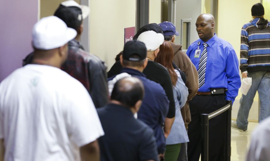 Parkland Hospital financial councilor Ricky Spain, right, answers questions for people as they wait in line to sign up for health care insurance at the business office of Parkland Hospital in Dallas, Monday, March 31, 2014. Monday is the deadline to sign up for private heath insurance in the online markets created by President Obama's heath care law. (AP Photo/LM Otero)