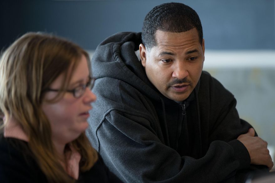Erik Furness meets with Antoinette Kraus with the Pennsylvania Health Access Network to begin the process of signing up for insurance under the Affordable Care Act, Monday, March 31, 2014, at Project HOME's St. Elizabeth’s Community and Wellness Center in Philadelphia. Furness, a 47-year-old barber says he wasn’t procrastinating, but needed to get his tax paperwork finished first. The deadline's just hours away to sign up for insurance in the first enrollment period under President Barack Obama's signature health care law. Health care advocates in Pennsylvania were pushing Monday to get as many people as possible to sign up. (AP Photo/Matt Rourke)
