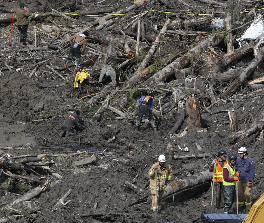 Workers and volunteers search for articles and belongings at the scene of the deadly March 22 mudslide, Monday, March 31, 2014, in Oso, Wash. The number of confirmed dead has reached 24. More than two dozen people remain missing, authorities have said. (AP Photo/The Herald, Sofia Jaramillo, Pool)