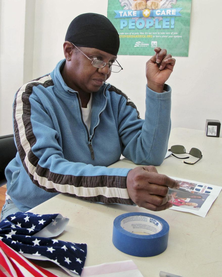 Karen Ruffin signs up for health care at Enroll America in Cincinnati Monday, March 31, 2014. Ruffin said she has been uninsured for about a year and put off signing up until Monday’s deadline because she thought the process would be much more difficult than it turned out to be. (AP Photo/Amanda Lee Myers)