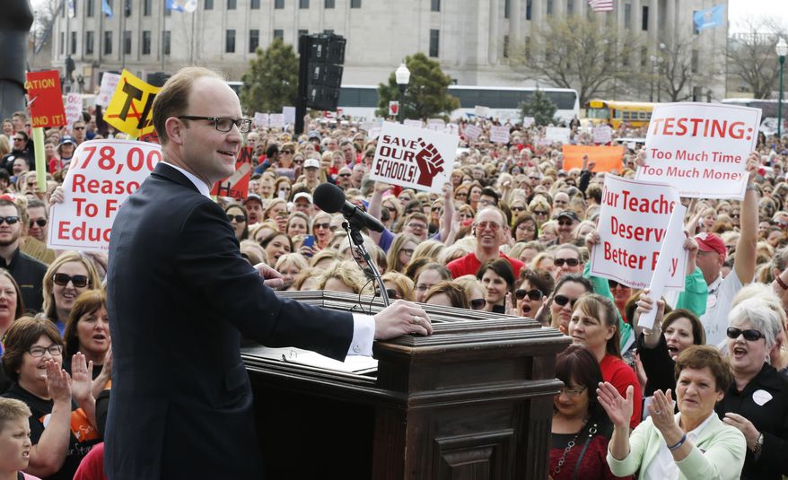 Oklahoma state Rep. Scott Inman, D-Del City, addresses a huge crowd of teachers, parents and children gathered at the Oklahoma Capitol building in Oklahoma City, Monday, March 31, 2014, to call for an increase in school funding, which hasn't reached its pre-recession levels despite the addition of tens of thousands more students to the state's classrooms. (AP Photo/Sue Ogrocki)