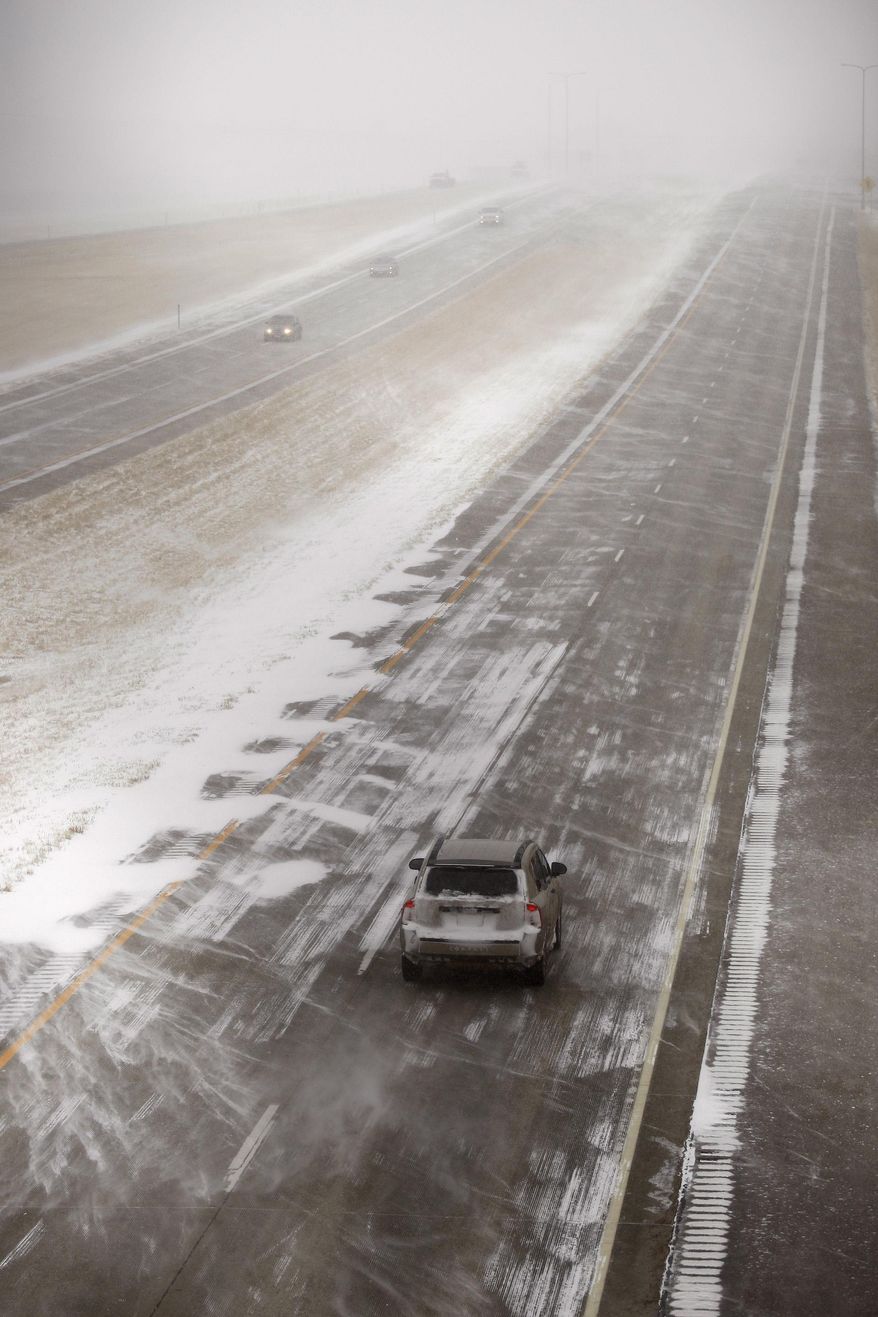 Cars drive along Interstate 90 near Black Hawk as a spring storm blasts the Black Hills in South Dakota on Monday, March 31, 2014. A spring snowstorm in the Upper Midwest on Monday shut down public schools, universities and government offices, made travel hazardous and life miserable for cattle ranchers in the midst of calving season. The National Weather Service issued blizzard warnings for much of the Dakotas and part of Minnesota, with the heaviest snow expected in eastern North Dakota and northwestern Minnesota. (AP Photo/Rapid City Journal, Benjamin Brayfield)