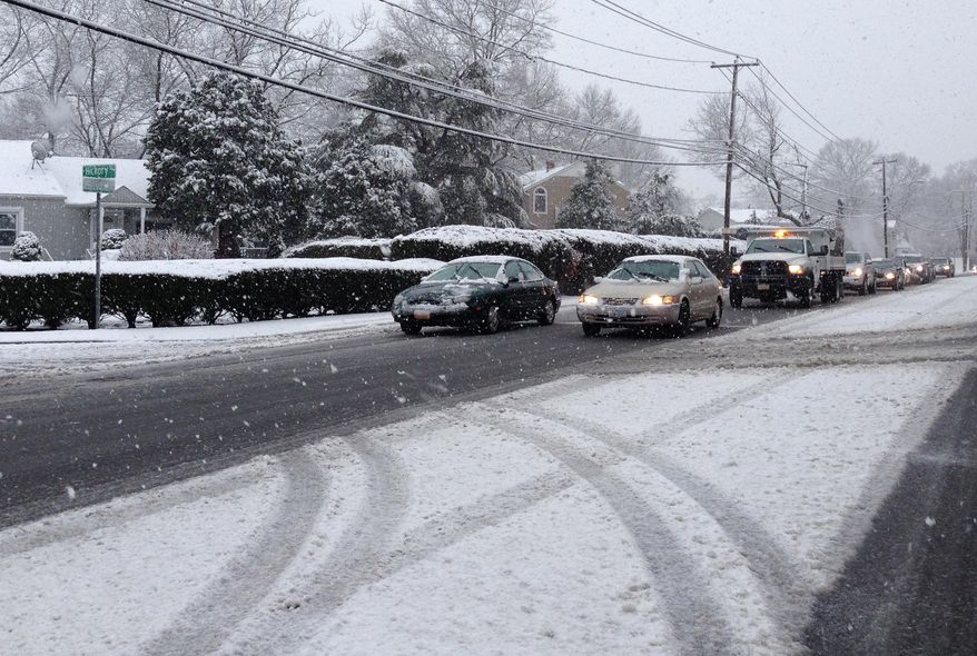 A spring snowfall covers a neighborhood, Monday, March 31, 2014 in Farmingdale, NY. Around an inch of snow covered vehicles and stuck to roads during the Monday morning rush-hour in Farmingdale, on Long Island. A dusting of snow also appeared north of the city, in Westchester County. (AP Photo/Frank Eltman)