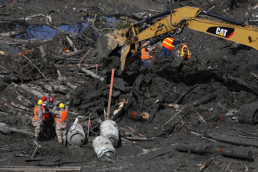 Workers and volunteers search for articles and belongings at the scene of the deadly March 22 mudslide, Monday, March 31, 2014, in Oso, Wash. The number of confirmed dead has reached 24. More than two dozen people remain missing, authorities have said. (AP Photo/The Herald, Sofia Jaramillo, Pool)