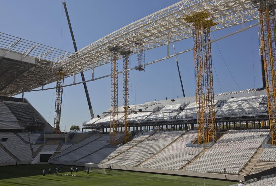FILE - In this March 15, 2014 file photo, Brazilian club Corinthians soccer players practice at the Itaquerao stadium in Sao Paulo, Brazil. Brazilian organizers are adding safety features where a worker died in the stadium hosting the World Cup opener, hoping to quickly reverse an order that halted construction in part of the venue. The addition of new safety rails comes a day after labor officials said the installation of 20,000 temporary seats at the Itaquerao stadium could not continue until safety concerns were addressed. On Saturday March 29th, 2014, a 23-year-old worker died after falling from about 26 feet while installing the seats needed for the opener. (AP Photo / Andre Penner, File)