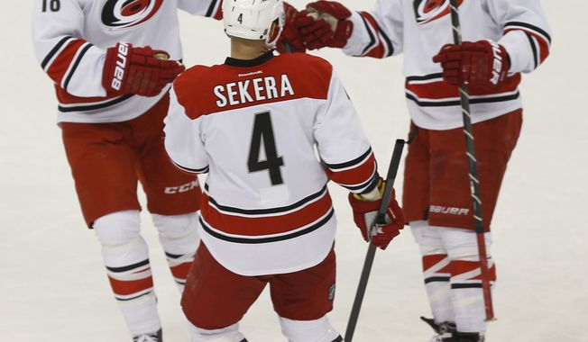 Carolina Hurricanes&#x27; Justin Faulk (27) celebrates scoring a goal with teammates Andrej Sekera (4), and Radek Dvorak (18), of the Czech Republic, during the first period of an NHL hockey game against the Pittsburgh PenguinsonTuesday, April 1, 2014, in Pittsburgh. (AP Photo/Keith Srakocic)