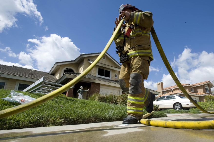 OCFA firefighters clean up after knocking down a house fire on the 21000 block of Todd Avenue in Yorba Linda, Calif., Tuesday, April 1, 2014. Authorities say four people were injured in a Southern California house fire including two deputies and a 90-year-old woman they tried to rescue. (AP Photo/The Orange County Register, Joshua Sudock)