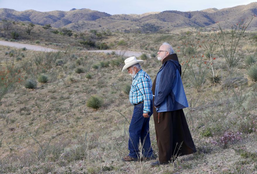 Boston Archdiocese Cardinal Sean O'Malley, right, walks Father Peter Neeley, of Nogales, during a tour of areas used for human smuggling, early Tuesday, April 1, 2014, along the international border in Nogales, Ariz. O'Malley and a delegation of Roman Catholic leaders who serve along the U.S./Mexico were visiting the border town to bring awareness to immigration reform and to remember those who have died trying to cross the border in years past. (AP Photo/Matt York)