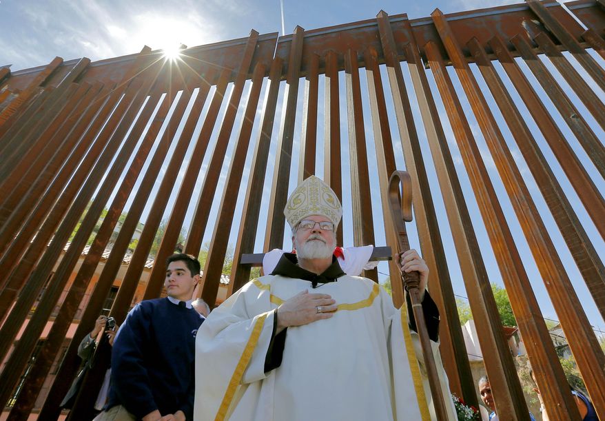 Cardinal Sean O'Malley leads mass, Tuesday, April 1, 2014, along the international border wall in Nogales, Ariz. A delegation of Roman Catholic leaders celebrated Mass along the U.S.-Mexico border to raise awareness about immigration and to pray for policy changes. (AP Photo/Matt York)