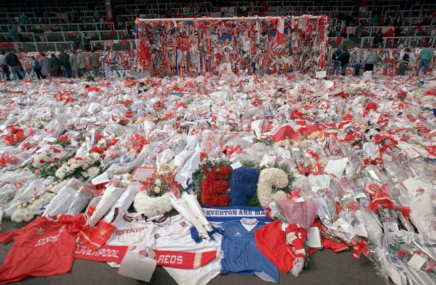 FILE- In this file photo dated April 17, 1989, floral tributes are placed by soccer fans at the 'Kop' end of Anfield Stadium in Liverpool, England, on April 17, 1989, after the Hillsborough April 15 tragedy when fans surged forward during the Cup semi-final between Liverpool and Nottingham Forest at Hillsborough Stadium killing 96 people. After years of campaigning to expose alleged wrongdoing by the authorities, new inquests into Britain’s worst sports disaster are beginning Monday March 31, 2014, with the families of the 96 Liverpool fans crushed to death at Hillsborough seeking verdicts of unlawful killing. (AP Photo/ Peter Kemp, FILE)