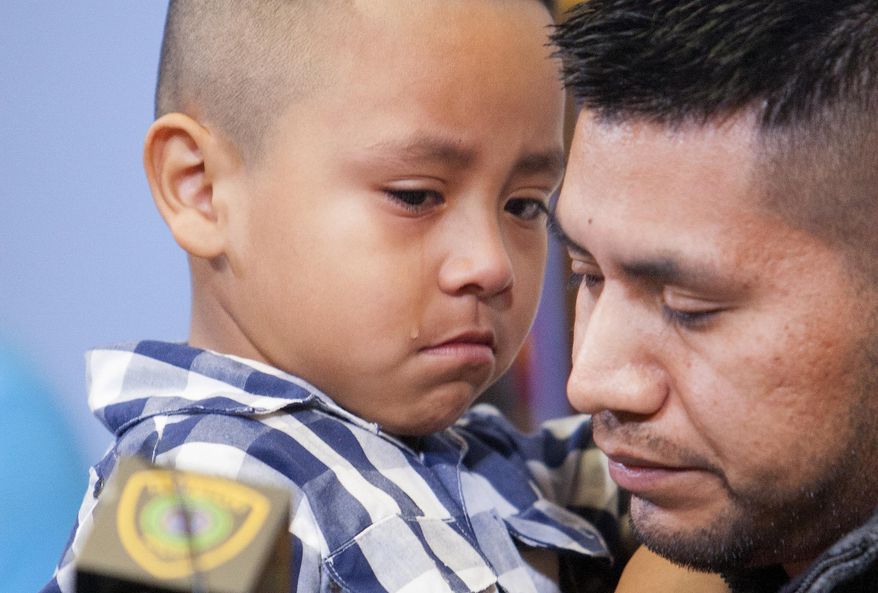 A tear rolls down the cheek of Jonathan Chamorro, 5, as he is held by his father German Chamorro, right during a news conference regarding the death of Maria Lucrecia, 27, Monday, March 31, 2014, in Houston. Lucrecia, Jonathan's mother and German's wife, was killed at the Eclipse Gentlemen's Club, Saturday, where she worked as a cleaning lady. Lucrecia was also pregnant. (AP Photo/Houston Chronicle, Cody Duty)