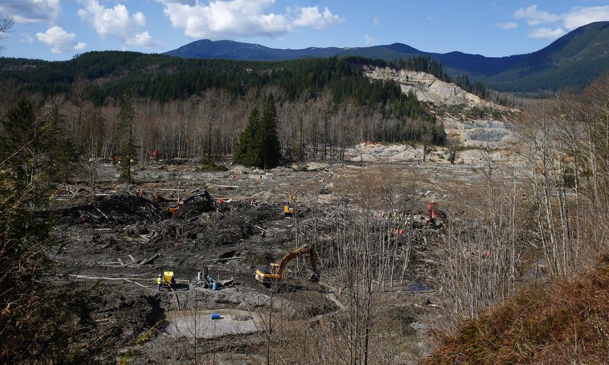 The scale of the mudslide's reach can be seen from an emergency and work access road, connecting Arlington to Darrington, as crews work to clear mud and debris at the west site of the mudslide on Highway 530, near Oso, Wash., on Tuesday, April 1, 2014. The death toll from the March 22 mudslide has increased to 28. (AP Photo/The Seattle Times, Lindsey Wasson) SEATTLE OUT; USA TODAY OUT; MAGS OUT; TELEVISION OUT; NO SALES; MANDATORY CREDIT TO BOTH THE SEATTLE TIMES AND THE PHOTOGRAPHER