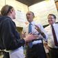 President Barack Obama, accompanied by Rep. Gary Peters, D-Mich., right, talks with employee Andrea Byl to order lunch during their visit to Zingerman&#39;s Deli in Ann Arbor, Mich., Wednesday, April 2, 2014. Afterward, the president traveled to the University of Michigan to speak about his proposal to raise the national minimum wage. (AP Photo/Carolyn Kaster)