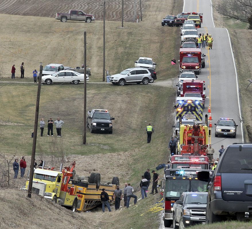 Emergency response personnel work at the scene of an overturned school bus near the rural northeast Missouri town of Ewing near the Illinois border Tuesday, April 1, 2014. Nearly two dozen students were injured who attended Highland Elementary and Highland High schools in the Lewis County C-1 District. Ewing is located about 125 miles northwest of St. Louis. (AP Photo/Quincy Herald Whig, Steve Bohnstedt)