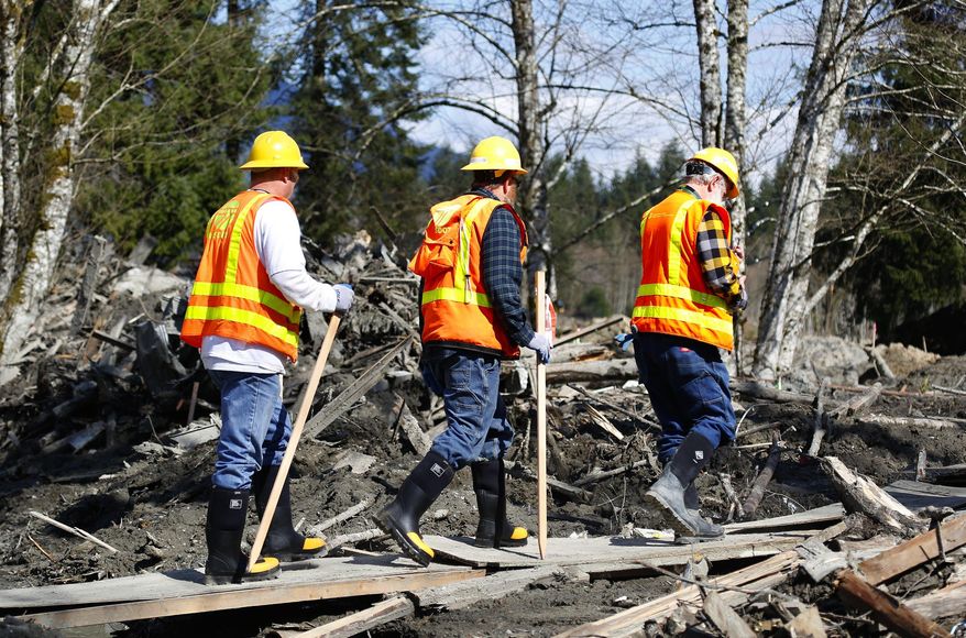 Washington State Department of Transportation workers enter the mudslide site on a constructed path of plywood on Highway 530 near mile marker 37, near Oso, Wash., Tuesday, April 1, 2014. The death toll from the March 22 mudslide has increased to 28. (AP Photo/The Seattle Times, Lindsey Wasson) SEATTLE OUT; USA TODAY OUT; MAGS OUT; TELEVISION OUT; NO SALES; MANDATORY CREDIT TO BOTH THE SEATTLE TIMES AND THE PHOTOGRAPHER