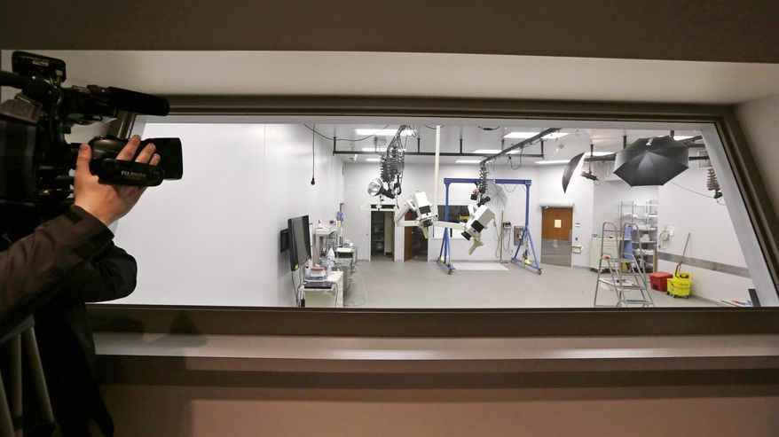 An autopsy room is seen by media members through a viewing window at the Snohomish County Medical Examiner's office, Wednesday, April 2, 2014, in Everett, Wash. The office is processing the remains of victims from the March 22 mudslide in nearby Oso, Wash., that has killed at least 29. Another 13 people are unaccounted for. (AP Photo/Elaine Thompson)