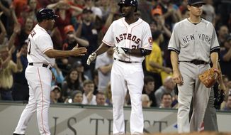 Houston Astros&#x27;s Dexter Fowler (21) is congratulated by third base coach Pat Listach, left, after hitting a triple in the third inning of an MLB American League baseball game against the New York Yankees, Wednesday, April 2, 2014, in Houston. (AP Photo/Patric Schneider)