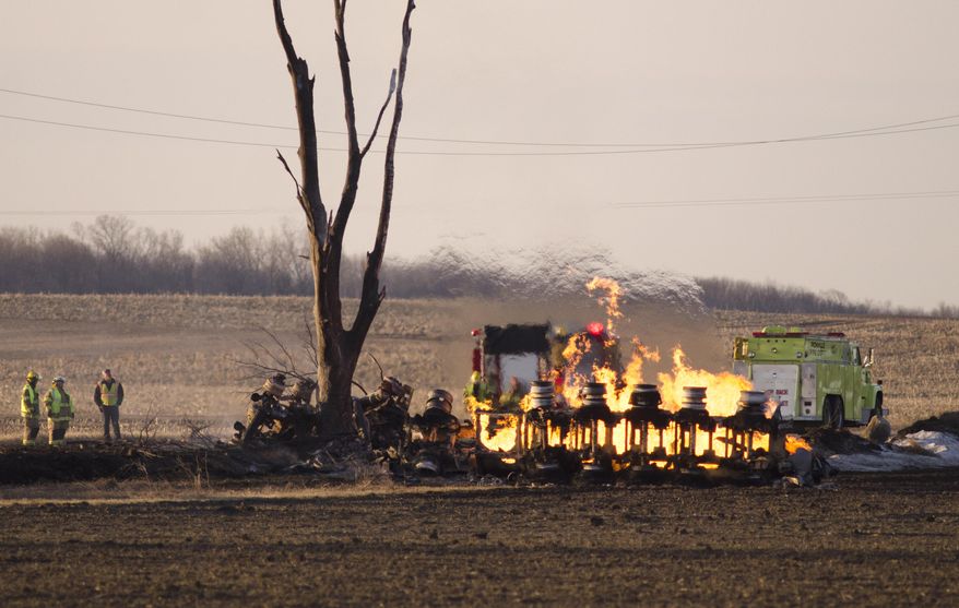 Richville Fire Department watch as a tanker burns after crashing in Reese, Mich. Wednesday, April 2, 2014. Authorities say one person is dead following a fuel tanker crash in rural Michigan that sent flames 150 to 200 feet into the air. Richville Fire Chief Eric Brown says the truck was carrying about 13,000 gallons of fuel. (AP Photo/The Saginaw News, Tim Goessman) ALL LOCAL TV OUT; LOCAL TV INTERNET OUT