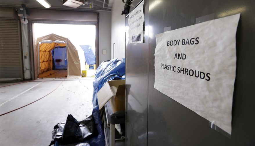 A tented area for decontaminating bodies is set-up just outside an intake area at the Snohomish County Medical Examiner's office, Wednesday, April 2, 2014, in Everett, Wash. The office is processing the remains of victims from the March 22 mudslide in nearby Oso, Wash., that has killed at least 29. Another 13 people are unaccounted for. (AP Photo/Elaine Thompson)