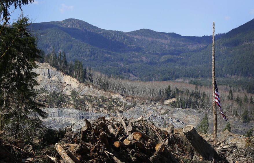 An American flag found in the debris hangs at half-staff on a single standing tree, with the slide site in the background, at the west site of the mudslide on Highway 530, near Oso, Wash., on Tuesday, April 1, 2014. The death toll from the March 22 mudslide has increased to 28. (AP Photo/The Seattle Times, Lindsey Wasson) SEATTLE OUT; USA TODAY OUT; MAGS OUT; TELEVISION OUT; NO SALES; MANDATORY CREDIT TO BOTH THE SEATTLE TIMES AND THE PHOTOGRAPHER
