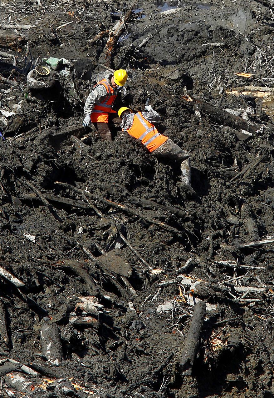 Rescuers work through deep mud at the site of a fatal mudslide on Tuesday, April 1, 2014, near Oso, Wash. The March 22 mudslide destroyed a rural mountainside community northeast of Seattle. (AP Photo/The Herald, Mark Mulligan) MANDATORY CREDIT.