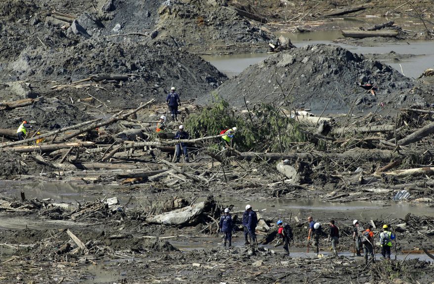 Workers search for victims and clear debris, Tuesday, April 1, 2014, near Darrington, Wash., at the site of the deadly mudslide that hit the community of Oso,Wash. on March 22, 2014. (AP Photo/Ted S. Warren)