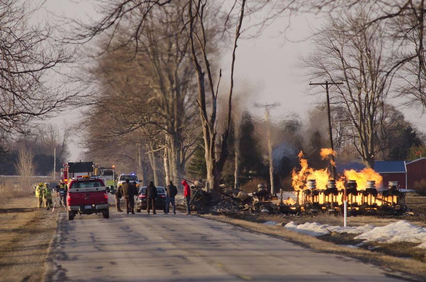 Emergency personnel look on as a tanker burns after a crash in Reese, Mich. Wednesday, April 2, 2014. Authorities say one person is dead following a fuel tanker crash in rural Michigan that sent flames 150 to 200 feet into the air. Richville Fire Chief Eric Brown says the truck was carrying about 13,000 gallons of fuel. (AP Photo/The Saginaw News, Tim Goessman) ALL LOCAL TV OUT; LOCAL TV INTERNET OUT