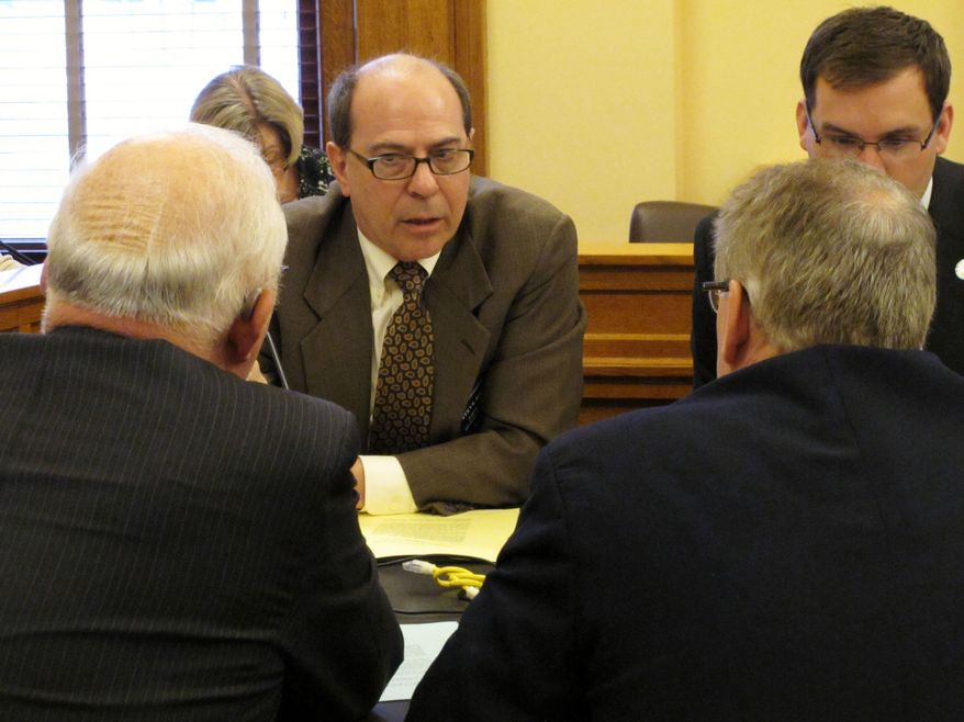 Kansas state Rep. Steve Brunk, center, of Wichita speaks with other Republican lawmakers during negotiations over gun-rights legislation, Wednesday, April 20, 2014, at the Statehouse in Topeka, Kan. The negotiations are clearing the way for a quick House vote on a Senate plan to strip cities and counties of their power to regulate guns. (AP Photo/John Hanna)