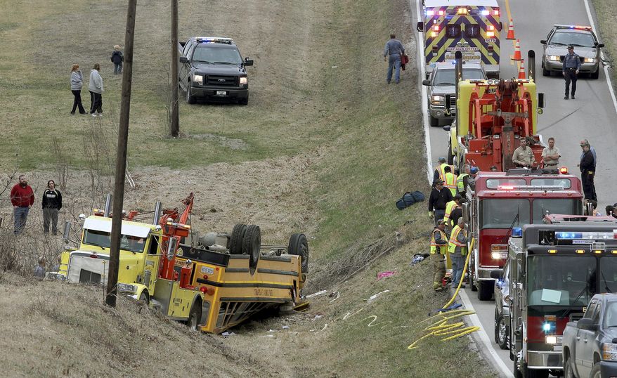 Emergency response personnel work at the scene of an overturned school bus near the rural northeast Missouri town of Ewing near the Illinois border, Tuesday, April 1, 2014. Nearly two dozen students were injured who attended Highland Elementary and Highland High schools in the Lewis County C-1 District. Ewing is located about 125 miles northwest of St. Louis. (AP Photo/Quincy Herald Whig, Steve Bohnstedt)