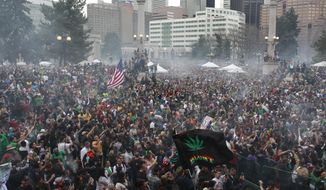 FILE - In this April 20, 2013, file photo, members of a crowd numbering tens of thousands smoke marijuana and listen to live music at the Denver 420 pro-marijuana rally at Civic Center Park in Denver. Organizers of Denver’s annual April 20 marijuana festival announced on Wednesday, April 2, 2014, that rapper B.o.B and singer Wyclif Jean will headline the event as they try draw a big post-legalization crowd and shake the memory of last year’s event, which was marred by a still-unsolved shooting. (AP Photo/Brennan Linsley, File)