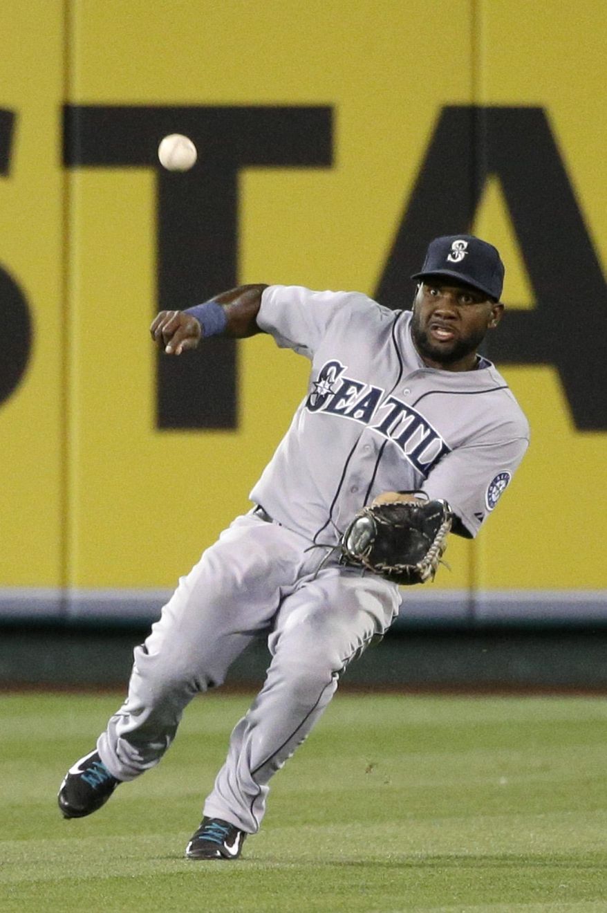 Seattle Mariners center fielder Abraham Almonte looks to catch a fly ball hit by Los Angeles Angels' David Freese during the first inning of a baseball game on Wednesday, April 2, 2014, in Anaheim, Calif. Almonte made the catch for the out. (AP Photo/Jae C. Hong)