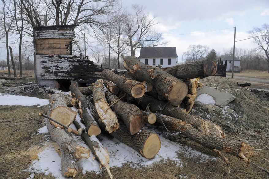A burnt out home and several tree limbs is spread on a lot, Tuesday March 25, 2014, on Crane near Charlevoix in Detroit's east side. A mass tree-planting effort is planned for May as part of a large-scale project. The May 17 event is planned by John Hantz where volunteers will help plant 15,000 young maple and oak trees on 50 acres of land where crews have been clearing blighted properties for the project. For the planting day, crews expect to have 15,000 pre-drilled holes ready. (AP Photo/Detroit News, Steve Perez) DETROIT FREE PRESS OUT; HUFFINGTON POST OUT