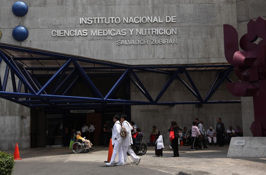 People walk outside the hospital where Colombian Nobel Literature laureate Gabriel Garcia Marquez is being treated in Mexico City, Thursday, April 3, 2014. Garcia Marquez was hospitalized with lung and urinary tract infections that are responding to treatment, federal health officials and the author's son said Thursday. (AP Photo/Marco Ugarte)