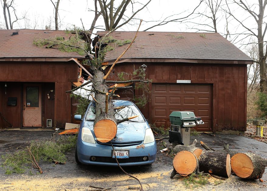 A strong storm sent a tree through his home and garage, landing on a car on Thursday, April 3, 2014 in Belleville, Ill. Portions of southern Illinois are being told to brace for a second round of potentially volatile storms after a possible tornado hit neighboring Missouri. The National Weather Service says the storm that swept across the St. Louis region Thursday morning caused no injuries or significant damage in the metropolitan area's Illinois suburbs. (AP Photo/St. Louis Post-Dispatch, Stephanie S. Cordle) EDWARDSVILLE INTELLIGENCER OUT; THE ALTON TELEGRAPH OUT