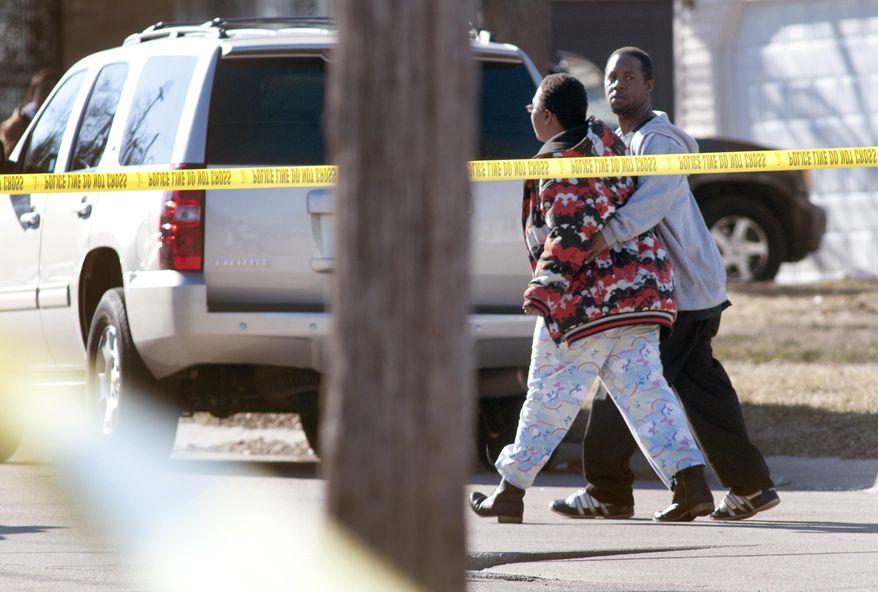 A man escorts a woman from the scene of a fatal shooting on Saginaw's northeast side, Wednesday, April 2, 2014. A male was confirmed dead behind the house. Hundreds of people took to the streets of Saginaw as part of an anti-violence effort that began the same day as the fatal shooting in the city. Police Chief Brian Lipe told the crowd that officers were investigating the city's first gun-related homicide of 2014. That announcement brought boos from the crowd, which included police, firefighters, community leaders and youth group members. (AP Photo/The Saginaw News, Jeff Schrier) ALL LOCAL TV OUT; LOCAL TV INTERNET OUT