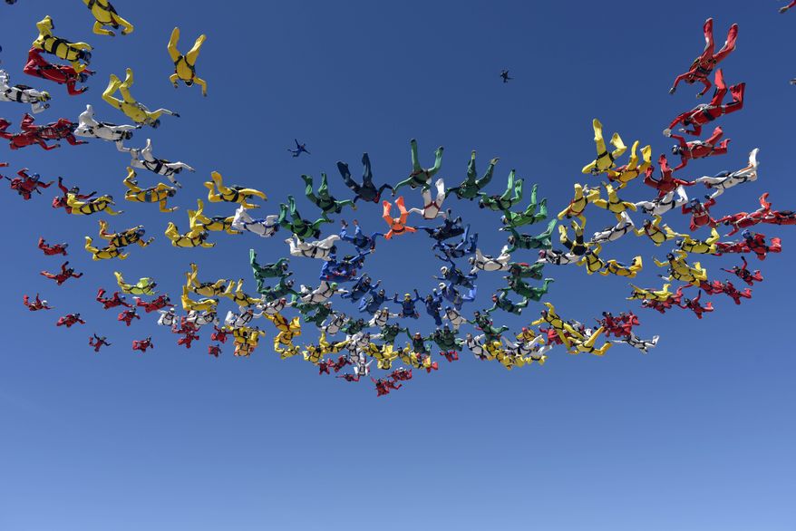 Members of the World Team join together in a missing man formation during a jump over Eloy, Ariz., Thursday, April 3, 2014, after one of the group died during a jump earlier in the day. The accident occurred as the group tried to set a world record by forming two distinct aerial formations within the same dive earlier Thursday morning. Skydive Arizona blamed the accident on a malfunctioning parachute that was released too low to the ground to allow a reserve parachute to fully open. (AP Photo/World Team, Henny Wiggers)