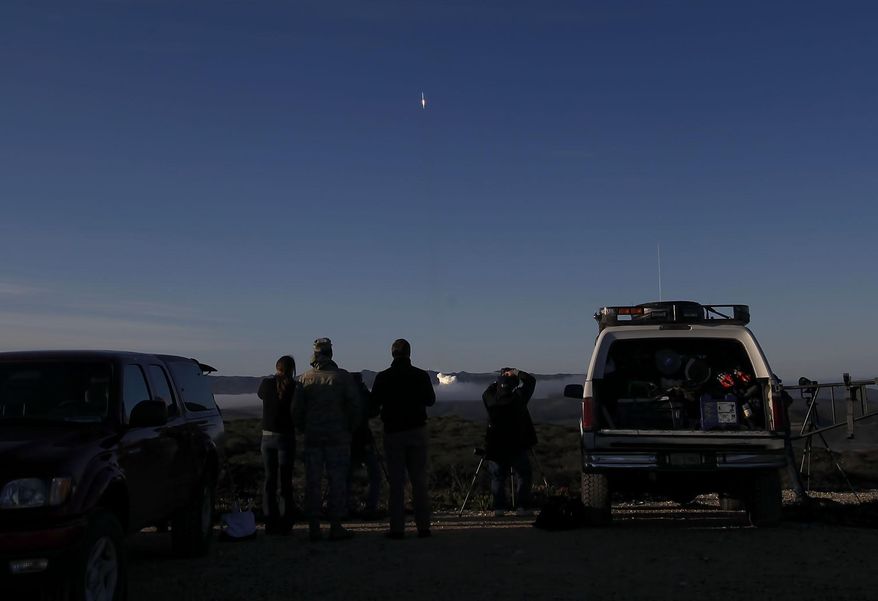 spectators and media watch as an Atlas 5 rocket launches from Vandenberg Air Force Base from Space Launch Complex-3 on Thursday, April 3, 2014. A United Launch Alliance Atlas V rocket carrying the 19th Defense Meteorological Satellite Program spacecraft blasted off at 7:46 a.m. PDT and quickly rose into the cold, clear sky above the launch site on the Pacific coast about 130 miles northwest of Los Angeles. The satellite will circle the Earth in a polar orbit at an altitude of about 525 miles (847 kilometers). (AP Photo/The Santa Maria Times, Daniel Dreifuss)