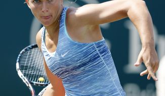 Sara Errani, of Italy, returns to Peng Shuai, of China, during the Family Circle Cup tennis tournament in Charleston, S.C., Thursday, April 3, 2014. (AP Photo/Mic Smith)