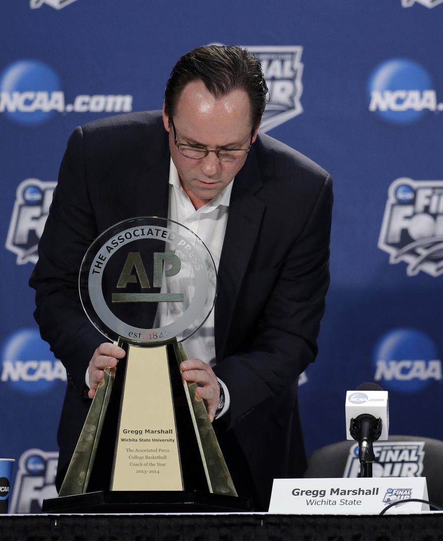 Wichita State's head coach Gregg Marshall looks at his trophy during a news conference Thursday, April 3, 2014, in Dallas. Marshall was named the AP College Basketball Coach of the Year. (AP Photo/David J. Phillip)